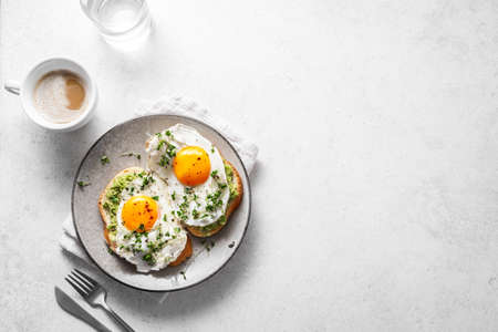 Avocado Egg Sandwiches for healthy breakfast. Whole grain toasts with mashed avocado, fried eggs and...