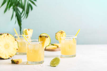Pineapple Margarita Cocktail. Summer boozy refreshing drink with tequila, pineapple in glasses with...