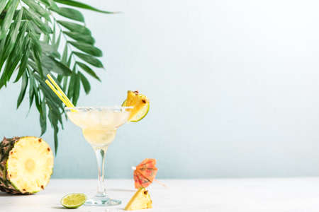 Pineapple Margarita Cocktail. Summer boozy refreshing drink with tequila, pineapple in glasses with salt rim, copy space.の写真素材