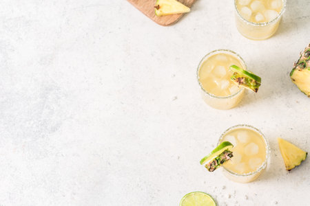 Pineapple Margarita Cocktail. Summer boozy refreshing drink with tequila, pineapple in glasses with salt rim, copy space.の写真素材