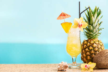 Summer tropical cocktail drink, fruits and flowers, blue sea background, copy space. Summer vacation and beach relax concept. Golden Eye pineapple and rum cocktail recipe.の写真素材