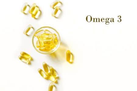 Oil filled capsules (softgel) of food supplements: fish oil, omega 3, omega 6, omega 9, vitamin A, vitamin D, vitamin D3, vitamin E, evening primrose oil, borage oil. Yellow softgels, top view, copy space.の写真素材