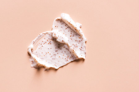 Sample of natural scrub on nude pink background. Peeling cream with microcapsules. Peach or coffee scrub smear.の写真素材
