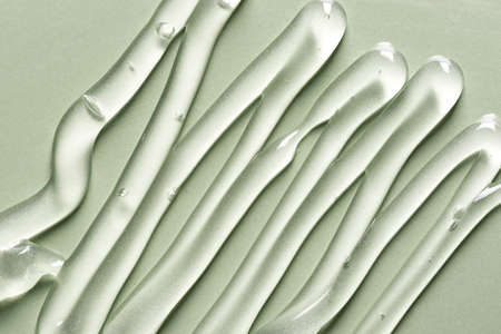 Gel texture on green background close up. Strokes of transparent gel cosmetic product.の写真素材