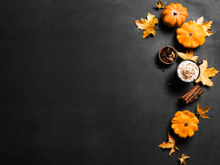 Autumn composition with pumpkins, maple leaves and pumpkin spice latte coffee on black, top view,...