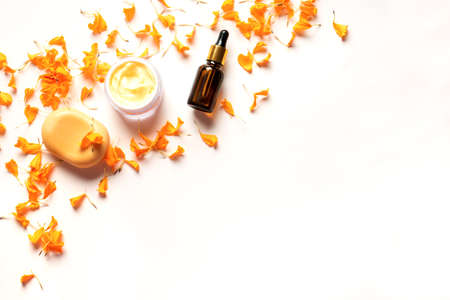 Herbal cosmetics with calendula flower petals. Natural organic moisturizing cream, skin care serum and soap isolated on white background, copy space.の写真素材