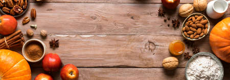 Autumn fall baking background with pumpkins, aples, nuts, food ingredients and seasonal spices. Cooking pumpkin or apple pie and cookies for Thanksgiving and autumn holidays.の写真素材