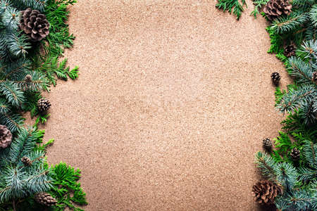 Christmas background with pine branches and cones on wooden, top view, copy space. Merry christmas...