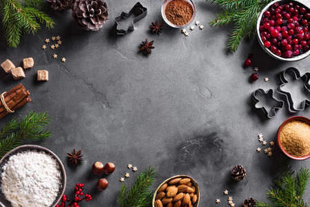 Christmas baking background with cranberris, nuts, food ingredients and seasonal spices, copy space. Cooking festive Christmas cookies for winter holidays.の写真素材
