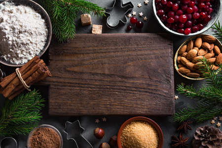 Christmas baking background with cranberris, nuts, food ingredients and seasonal spices, copy space. Cooking festive Christmas cookies for winter holidays.の写真素材