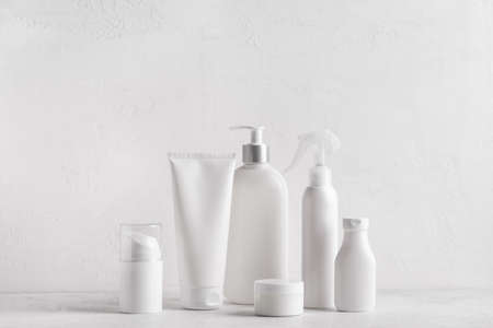 White jars, tubes and bottles cosmetic containers on white background, copy space. Bath skin care...