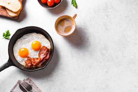 Fried eggs and bacon, coffee for breakfast served on white table, top view, copy space. american breakfast. good morning concept.の写真素材