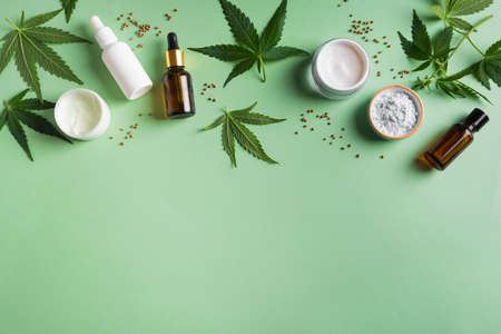 Hemp cannabis leaves and beauty products, cbd oil in bottle, face creme and serum, alternative medicine and organic skin care concept. copyspace.の写真素材