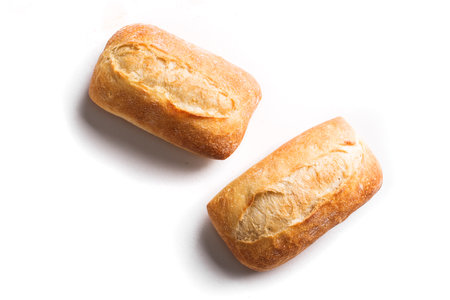 Fresh homebaked artisan bread. Two mini baguette bread isolated on white background, design element.の写真素材