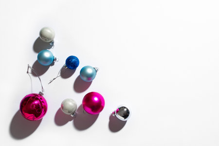 Christmas tree baubles, festive trendy composition with hard light and shadows on white background, copy space. Christmas, New Year holiday minimal creative concept.の写真素材