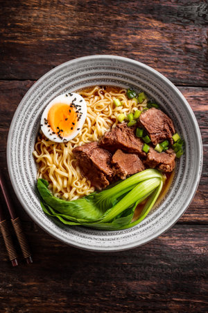 Miso Ramen Asian noodles soup with beef, egg and pak choi cabbage on dark wooden background. Noodle meat soup.の写真素材
