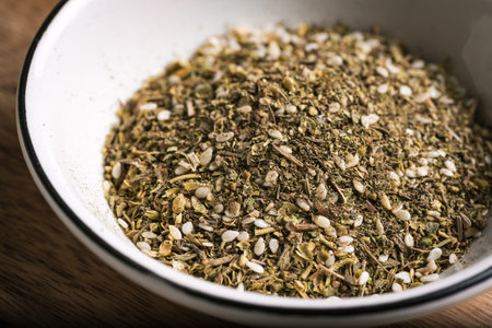 Mixed zaatar or zatar spices in white bowl close up. Oriental herbal seasoning zaatar or zattar. Arabic food.の写真素材