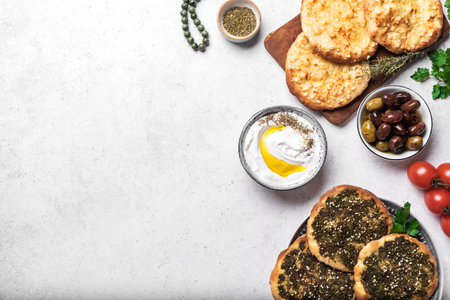 Arabic breakfast, labneh yogurt, manakeesh or pita bread with cheese and zaatar, olives and vegetables, copy space. Middle eastern meal, Arabic cuisine.の写真素材