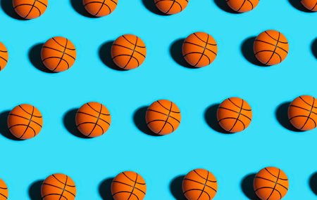 Trendy pattern made with orange ball for basketball on bright blue background. Minimal trendy sport concept.の写真素材