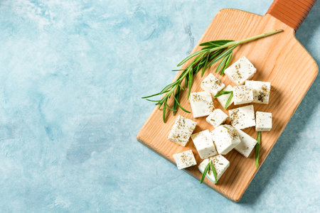 Fresh Greek Feta Cheese. Healthy ingredient for cooking salad. Chopped Goat feta cheese with rosemary herbs, copy space.の写真素材