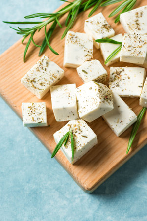 Fresh Greek Feta Cheese. Healthy homemade ingredient for cooking salad. Chopped Goat feta cheese with rosemary herbs close up.の写真素材