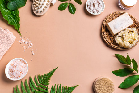 spa background. Natural organic spa cosmetics products with green leaves, eco friendly bath accessories. Bodycare massage concept on pink beige background, frame, copy space.の写真素材