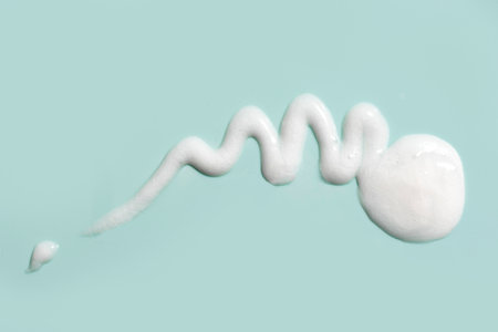 Cosmetic wash gel smudge drop texture on blue background. Sample of liquid white gel or face moisturizer.の写真素材