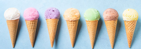 Various ice cream scoops in cones on blue background, banner. Set of organic vegan colorful ice...