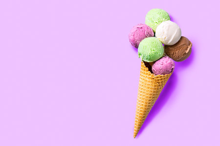Ice cream cone with various scoops on purple pastel background, creative flat lay, copy space. Many...