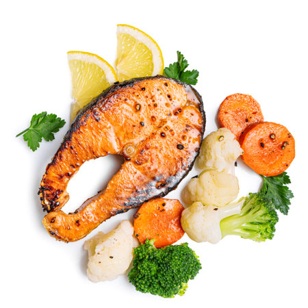 Grilled salmon fish steak with steamed vegetables isolated on white background, top view. Healthy fitness food, keto diet meal, design elements.の写真素材