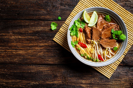 Pho Bo Vietnamese soup, bowl of fresh Asian soup with noodle, beef meat, herbs, soy sprouts and...