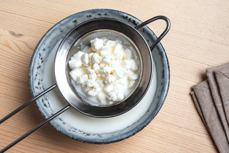 Milk kefir grains on stainer, top view, close up. Preparing healthy fermented probiotic milk kefir drink.の写真素材