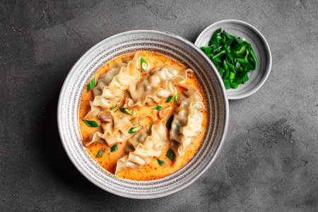 Thai Coconut Curry Dumpling Soup on concrete background, top view. Red curry wonton soup.の写真素材