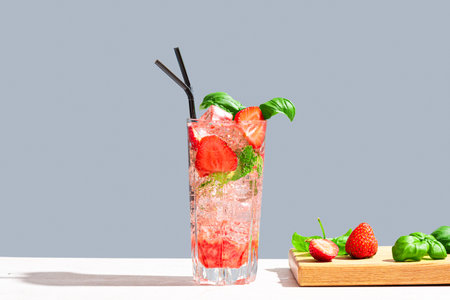 Glass of Strawberry and basil Mojito cocktail or mocktail on neutral gray background, copy space. Trendy sparkling drink, summer cocktail party and relaxation concept.の写真素材