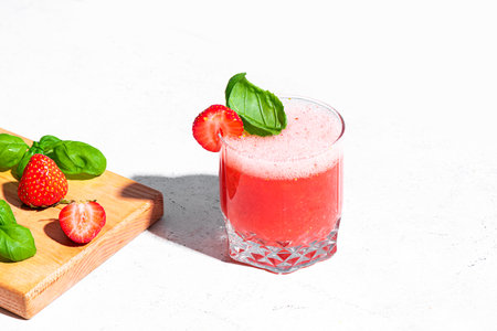 Refreshing Strawberry Basil Smash Cocktail, glass of blended strawberry drink on white background, copy space. Summer cold drink.の写真素材