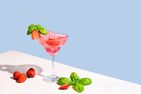 Fresh strawberry summer cocktail. Glass of strawberry and basil daiquiri, trendy mocktail on light blue background, copy space. Creative summer cocktail party concept.の写真素材