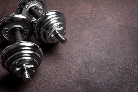 Heavy dumbbells (barbells) on dark background, copy space. Sport, fitness and healthy lifestyle...