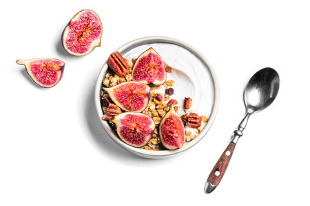 Granola bowl with figs and pecan nuts isolated on white background. Breakfast bowl with Greek...