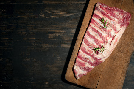 Raw pork ribs ready to cook, on wooden background, top view, copy space. Pork sparerib, recipe template.の写真素材