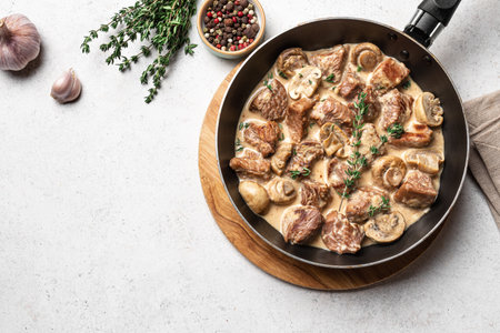 Creamy Chicken or Turkey Meat and Mushroom Stew with white wine sauce and thyme, white background, copy space. Homemade hearty comfort food.の写真素材