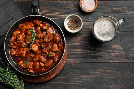 Beef Meat Stew with Dark Beer, homemade rich comfort meal. Braised Beef and beer on wooden, top view, copy space.の写真素材