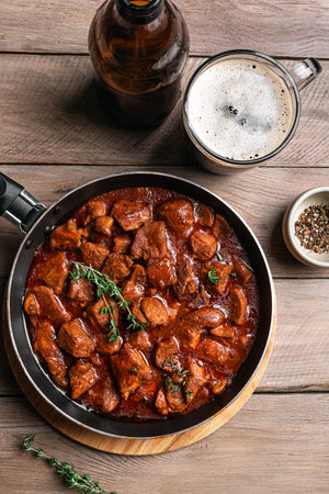 Beef Meat Stew with Dark Beer, homemade rich comfort meal recipe. Braised Beef and beer on wooden, top view.の写真素材