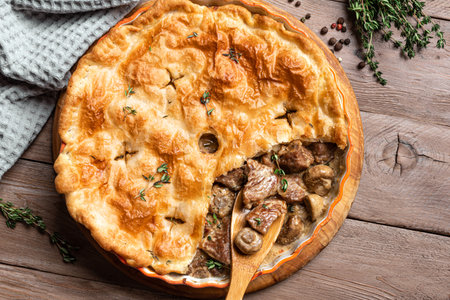 Turkey Meat and Mushroom Pie on wooden background, top view. Seasonal hearty comfort meal - homemade creamy turkey meat pie for Thanksgiving.の写真素材