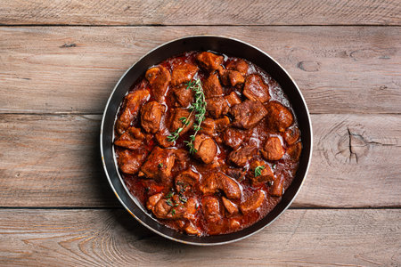 Red Wine Braised Beef or Beef Bourguignon Stew on wooden background, top view. Hearty comfort meal. Homemade meat recipe for winter holidays.の写真素材