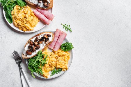 Healthy balanced breakfast template. Scrambled eggs, ham, sandwich with cream cheese and fried...