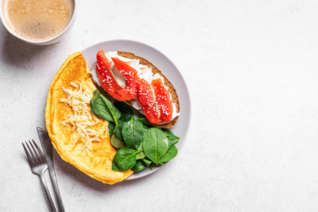 Healthy balanced breakfast. Omelette, spinach, wholegrain sandwich with cream cheese and salmon and...