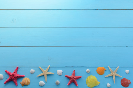 Summer sea background - shells, star on a wooden blue backgroundの写真素材