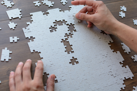 Image of businesswoman connecting elements of white puzzleの写真素材