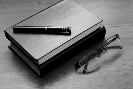 Book, notebook, pen and glasses on the desk. Business, science and education. Working background.の写真素材