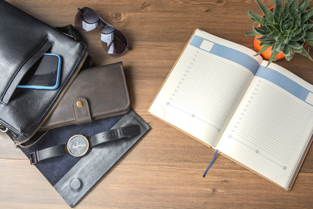Men's accessories - a purse, glasses, a bag, a business card, a clock, car keys, a phone, a tablet, a notebook and a pen on the office desk. Business and finance. Lifestyle and fashion.の写真素材